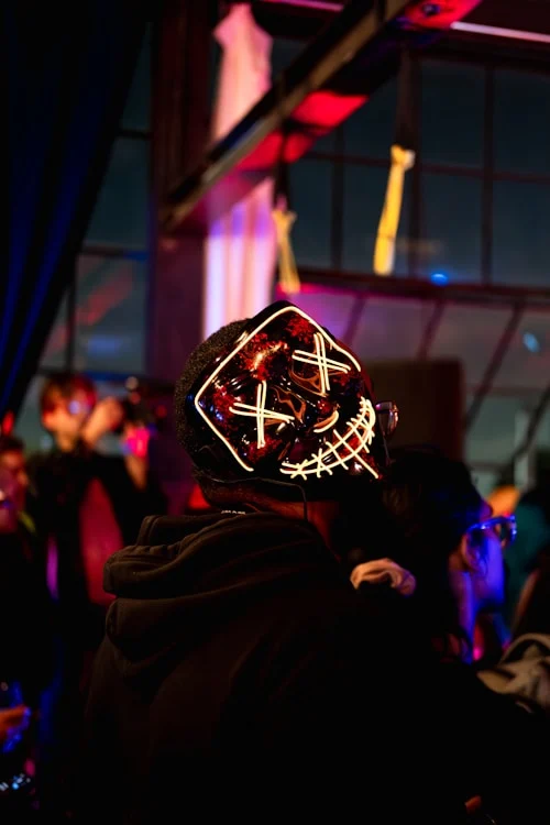 Festival attendee wearing Beatnix Costume Shop LED masks in a dark crowd