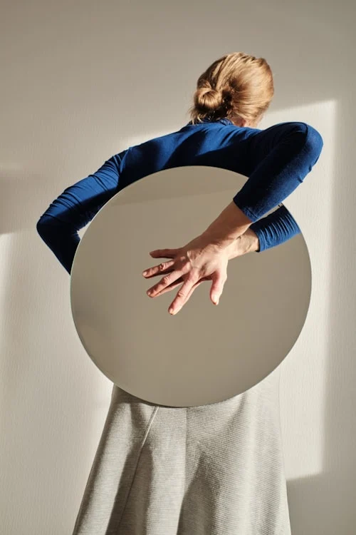 Woman styling vintage costume footwear with a retro outfit in front of a mirror
