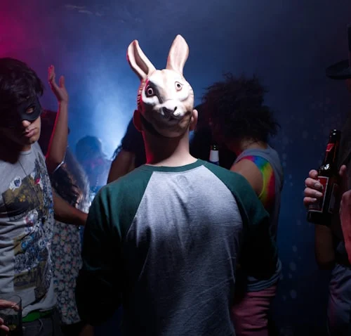 Festival attendee wearing sound reactive masks while dancing at an outdoor EDM concert