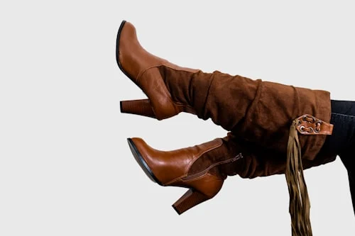 Woman trying on Beatnix Costume Shop knee high boots for a wide-calf fit